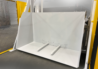 100-inch-wide Lift and Dump container dumper unloading scrap plastic from 96-inch-wide carts or skids into a shredder; features built-in forks for cart engagement, durable construction, compact footprint, and hydraulic operation for heavy-duty, maintenance-friendly material handling.