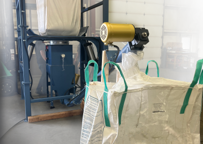 Bulk bag unloader with a screw conveyor to transfer material to downstream equipment.